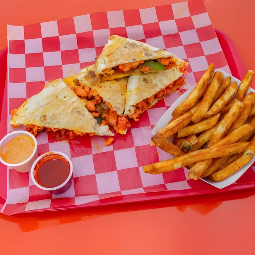 Chopped Cheese House quesadillas with fries and dipping sauces on a red and white checkered tray.